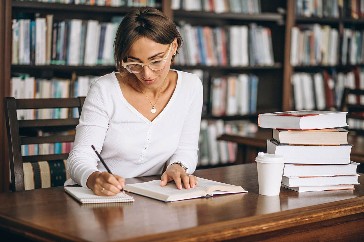 Reader studying in a library with coffee